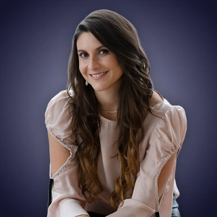 Man with crossed arms wearing a black Tether shirt standing confidently in front of a wall with Tether logos.