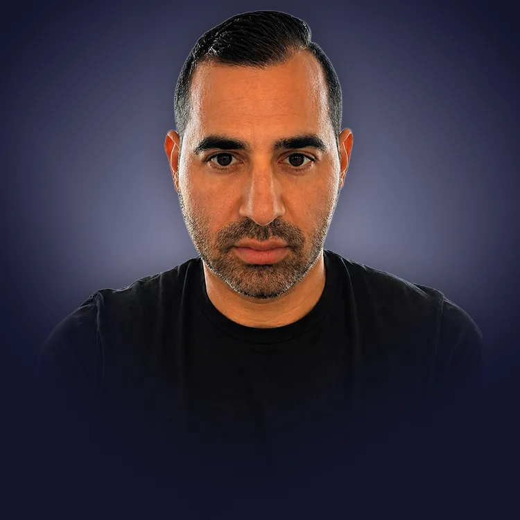 Man with crossed arms wearing a black Tether shirt standing confidently in front of a wall with Tether logos.