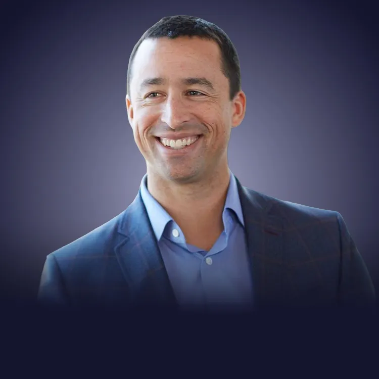Man with crossed arms wearing a black Tether shirt standing confidently in front of a wall with Tether logos.