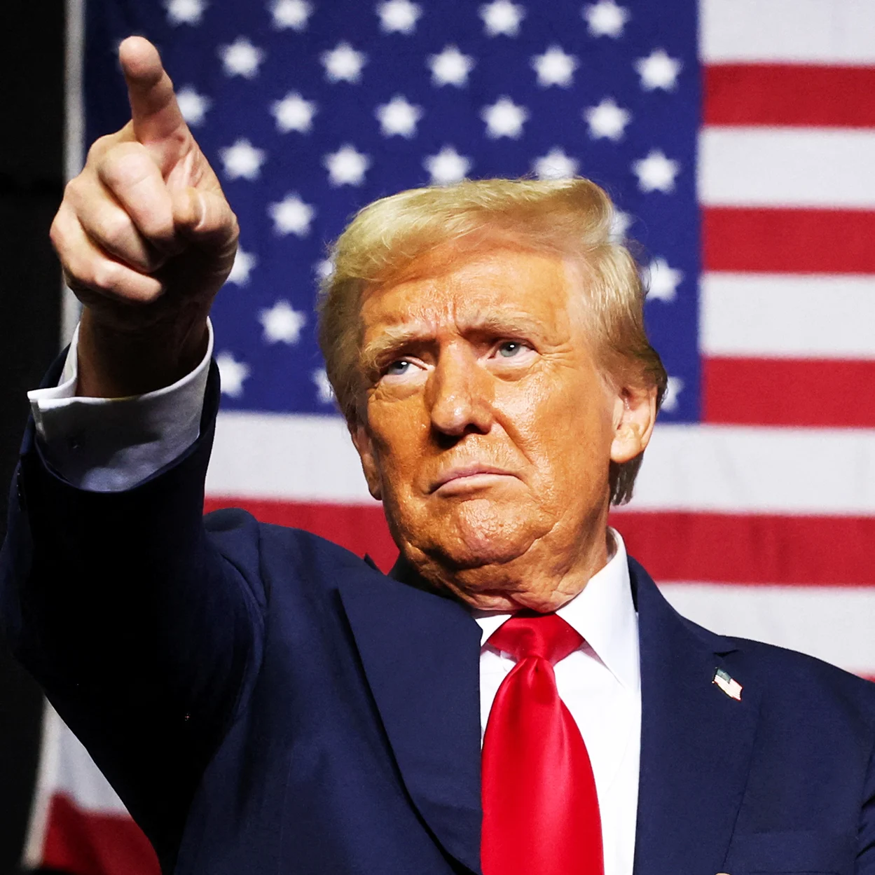 President Donald J. Trump pointing forward in front of the American flag