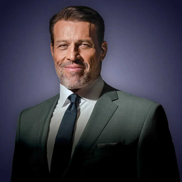 Man with crossed arms wearing a black Tether shirt standing confidently in front of a wall with Tether logos.